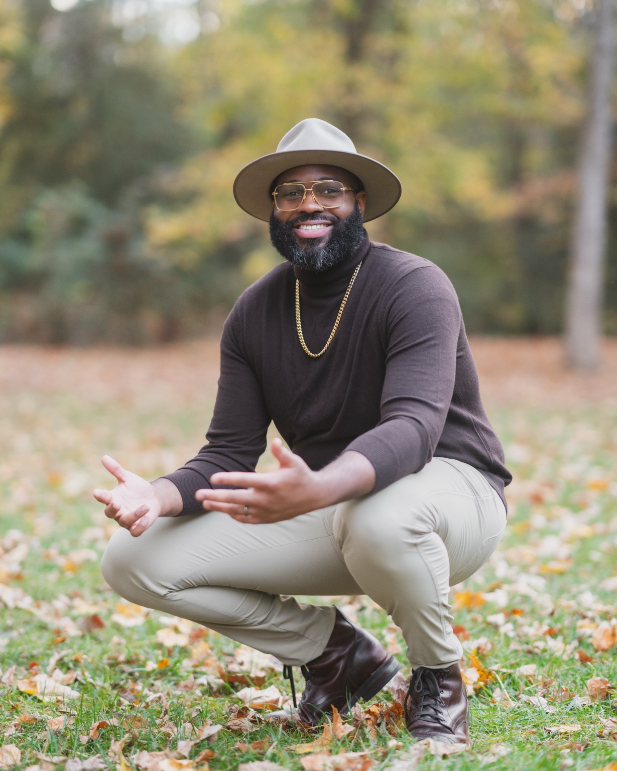Dob Njinimbam smiling outdoors, with his hands open.